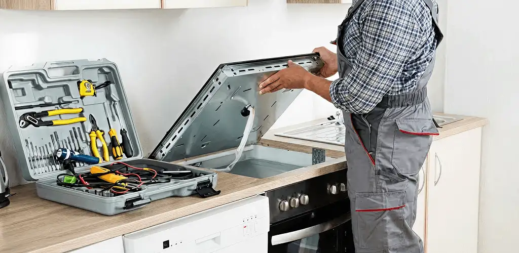 Handyman repairing a cooktop and checking wiring connections in Tulsa, OK