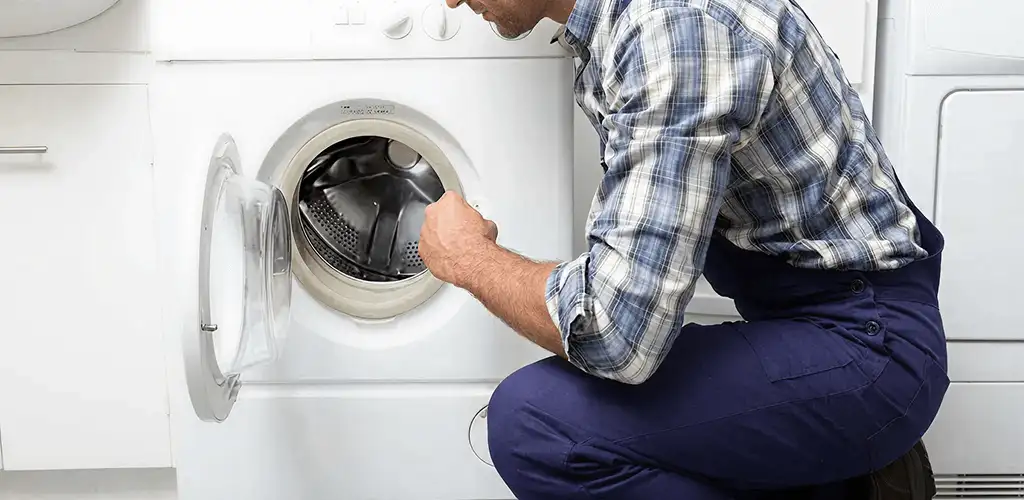 Handyman inspecting a dryer drum and internal parts for repair in Tulsa, OK