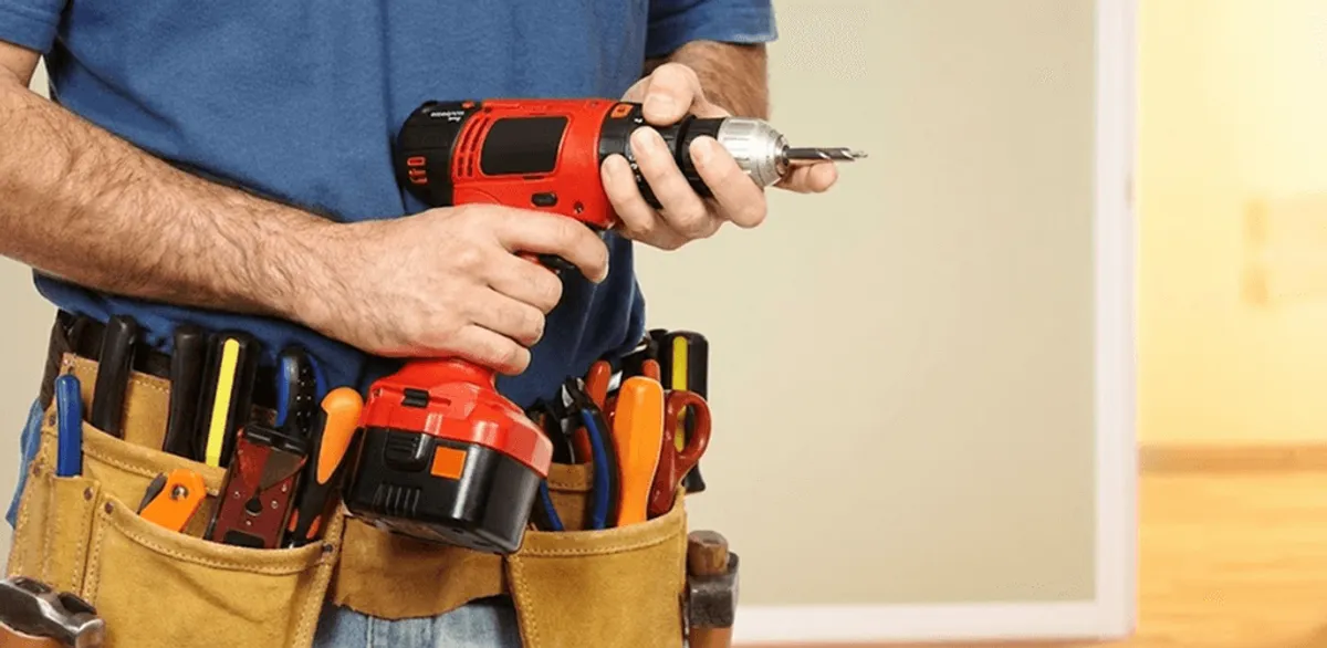 Handyman holding a power drill for home repairs and installations in Tulsa, OK