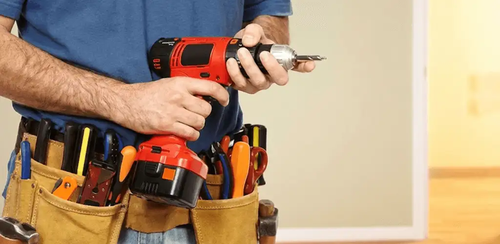 Handyman holding a power drill for home repairs and installations in Tulsa, OK