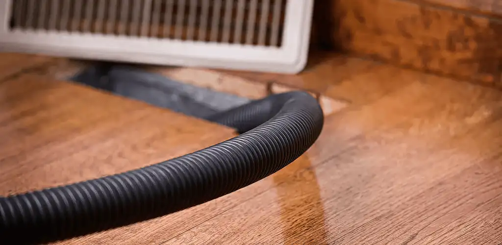 Air duct cleaning hose inserted into a floor vent for ductwork cleaning in Tulsa, OK
